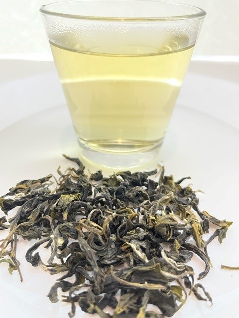Brewed Organic Blossom Green Tea and its dry leaves